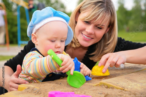 Photo: mother and child play in sandbox mother and child play in sandbox