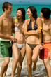 Four friends on the beach with drinks