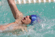 Swimmers swimming backstroke event in blue water
