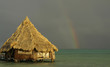Rainbow, beach hut and sea converge