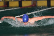 Butterfly stroke by male swimmer with blue cap