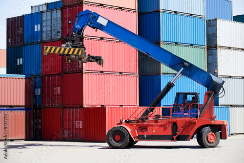 Photo: containers stacked in port with container handler / forklift containers stacked in port with container handler / forklift