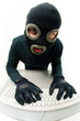 Criminal in balaclava pressing buttons of keyboard