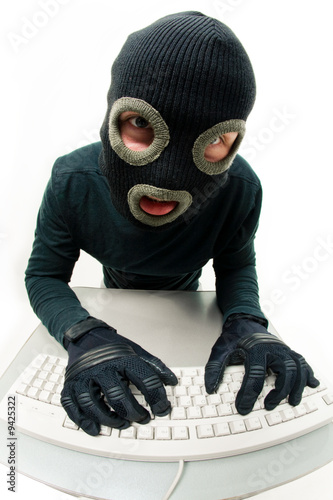 Criminal in balaclava pressing buttons of keyboard