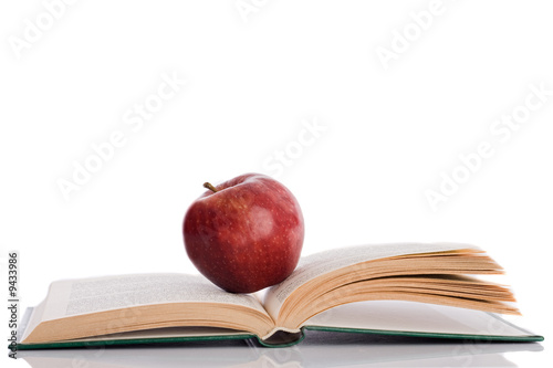 Photo: Red apple with open book and reflection on the floor Red apple with open book and reflection on the floor