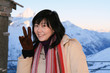 An asian woman at the Swiss Alps showing the victory sign.