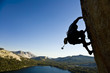 A rock climber desperately clinging to a rock face.