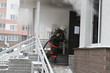 Firefighter pulling hose into blazing building