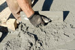 Closeup of mason's hand spreading concrete mix Closeup of mason's hand spreading concrete mix