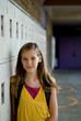 Cute preteen, teen or tween blonde standing against her locker.
