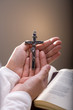Christian believer holding old cross in hand.
