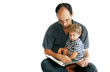 father reading a book to his son