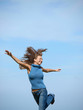 woman wearing a sweater and jens running in a field