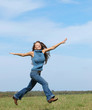 woman wearing jeans and a sweater running in field