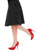 Legs of woman in red stilettos and black polka dot skirt