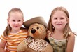 Studio portrait of two sister with bear toy - isolated