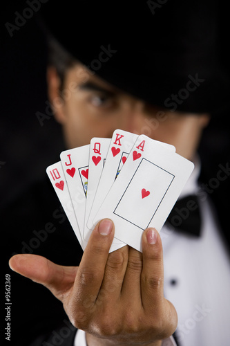 Photo: elegant man with Royal Flush Poker Hand - focus on cards elegant man with Royal Flush Poker Hand - focus on cards