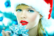 Beautiful woman wearing santas hat next to christmas tree