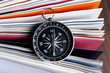 Magnetic compass on a book with wooden background
