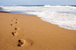 Photo: Human footprints leading away from the viewer into the sea Human footprints leading away from the viewer into the sea