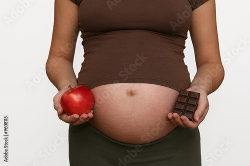 Pregnant woman  with apple and chocolate.Third trimester.