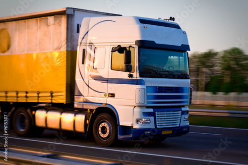 Photo: Freight truck on the highway, close view Freight truck on the highway, close view