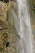 a man rappelling in a waterfall