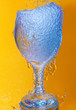Wineglass overflowing with water bubbles