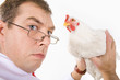 Photo of serious man holding white hen in hands