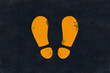 Yellow footsteps marking on black fresh asphalt pavement Yellow footsteps marking on black fresh asphalt pavement
