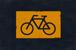 Yellow bicycle marking on black fresh asphalt pavement Yellow bicycle marking on black fresh asphalt pavement
