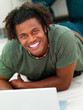 Portrait of a young man relaxing on the floor with laptop Portrait of a young man relaxing on the floor with laptop