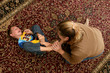 mother tickling her son's bare feet on the floor