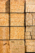 A large stack of new wooden studs at a lumberyard