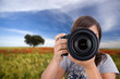 young woman with landscape as background taking photos