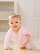 Photo: Close up of smiling baby crawling on livingroom floor Close up of smiling baby crawling on livingroom floor