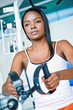 girl at the gym doing back machine weight training