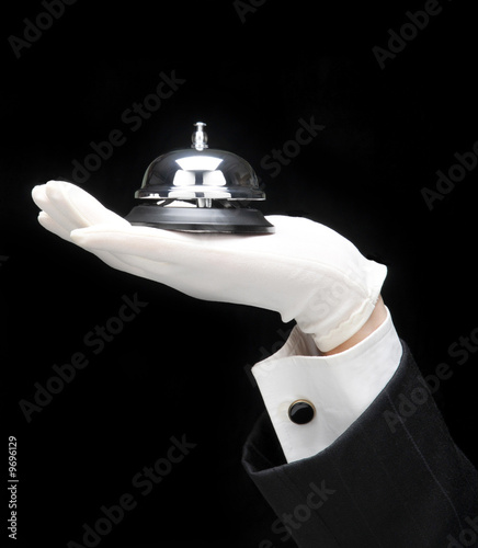 Butlers outstretched hand and arm with call bell