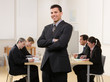 Photo: Confident businessman with co-workers in conference room Confident businessman with co-workers in conference room