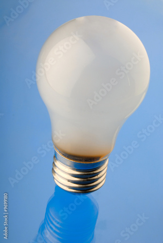 Photo: electric lamp of white color on blue background, close up electric lamp of white color on blue background, close up