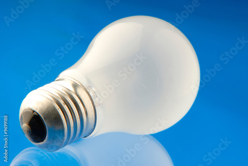 Photo: electric lamp of white color on blue background electric lamp of white color on blue background