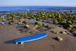 Blue Surfboard abandoned on the beach framed horizontally.
