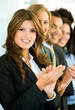 business team clapping in an office facing the camera
