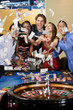 Group of friends gambling in casino looking happy.