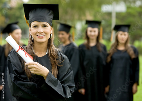Photo: graduation group of students with a woman leading smiling graduation group of students with a woman leading smiling