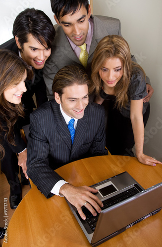 Photo: business team browsing on a laptop in their office business team browsing on a laptop in their office