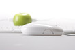 An apple on desktop whit keyboard and mouse on white background