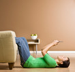 Photo: Woman laying on floor in livingroom text messaging on cell phone Woman laying on floor in livingroom text messaging on cell phone