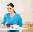Woman writing check from checkbook to pay monthly bills