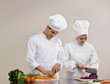 Chefs whites preparing and chopping fresh vegetables